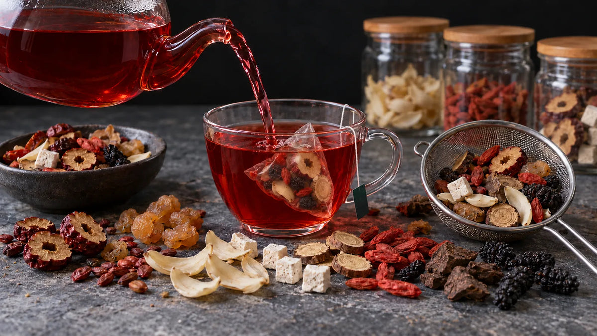 Ruby-red Chinese sleep tea poured into a glass cup with a LunarSip pyramid tea bag, with sour jujube seed, lily bulb, poria, longan and red date